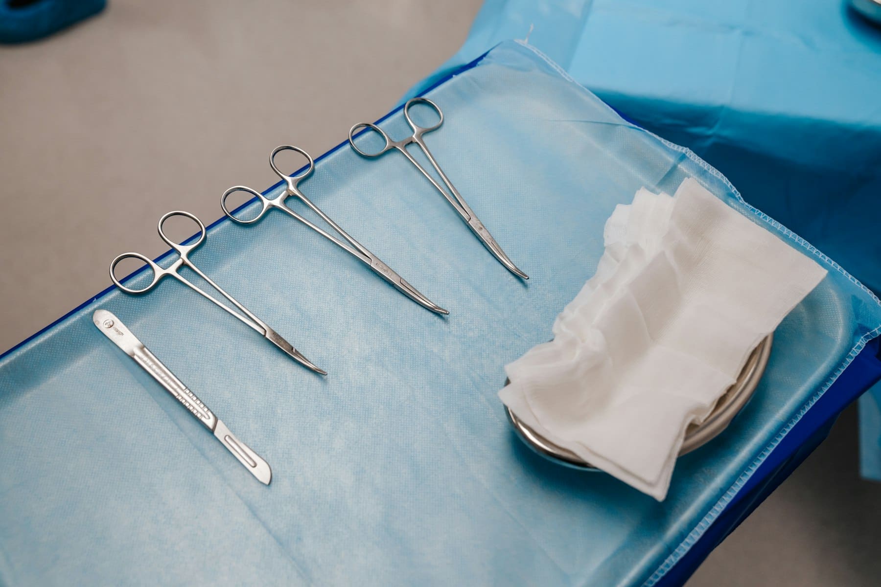 Sterile surgical instruments laid out on a blue cloth tray