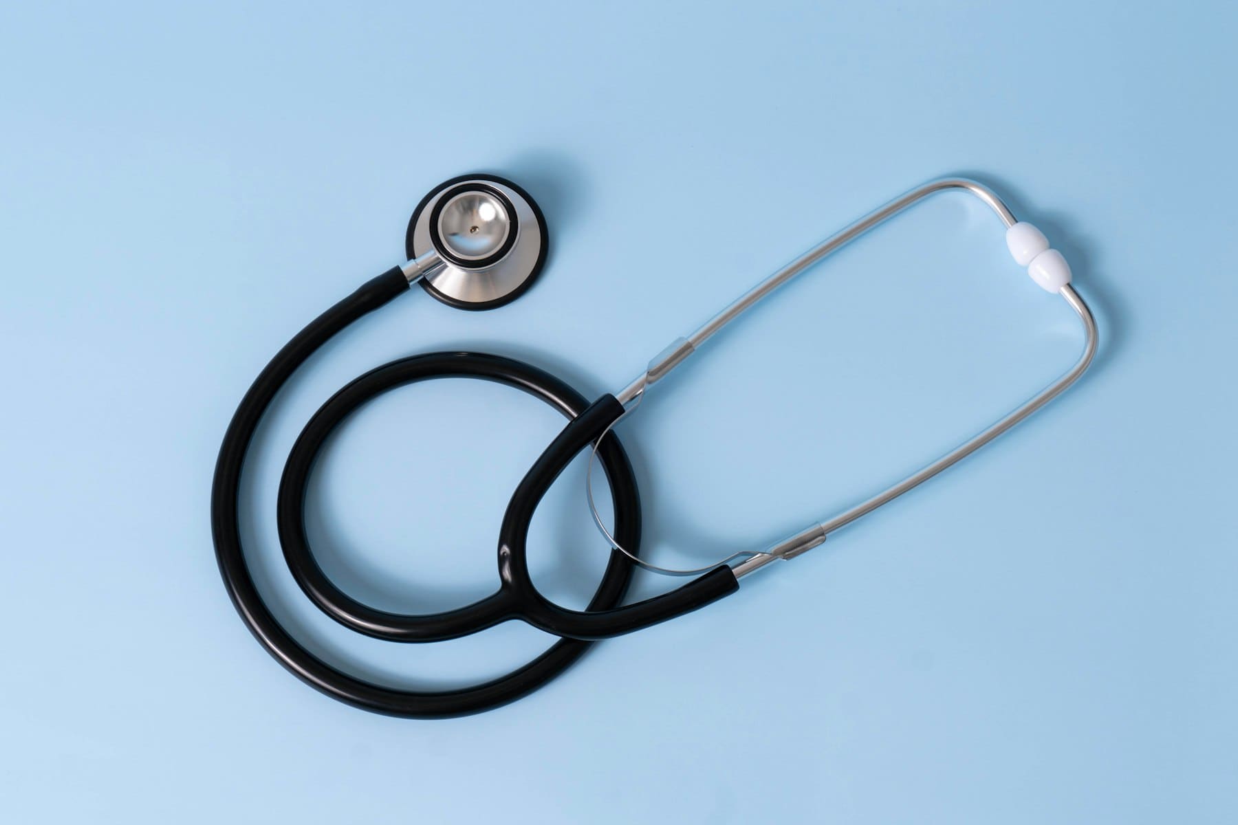 A stethoscope resting on a soft blue background